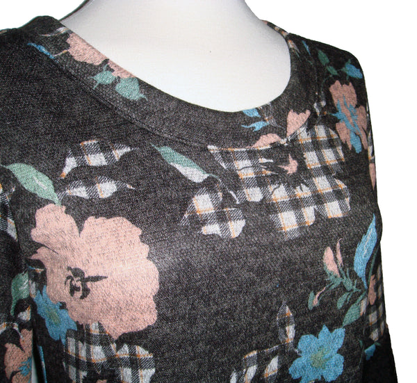Fun knee length dress with plaid and florals. blue flowers, pink flowers, and charcoal and beige plaid flowers, all on a charcoal background. 3/4 length sleeve with flounce cuff. crew neck style with pockets. fabric is stretchy knit with 2% spandex. other fabrics are rayon and poly.